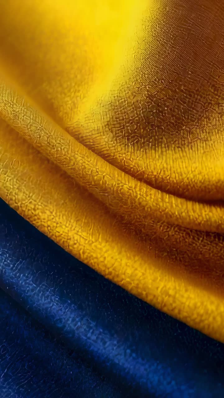 Video verticale: Lente che zooma mostrando un panno giallo su blu con una toppa rossa in studio, rivelando la trama.