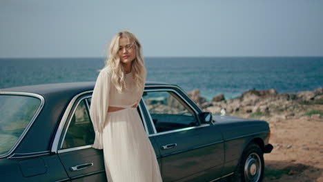 woman posing leaning car at beautiful ocean coast. girl enjoy road trip seashore