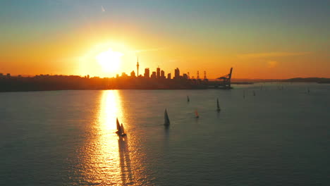 Toma-Aérea-De-La-Vibrante-Puesta-De-Sol-De-La-Ciudad-De-Auckland-Y-La-Bahía-De-Okahu-En-Primer-Plano