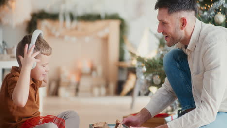 father and son unpacking christmas presents