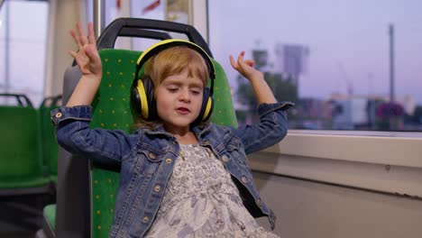 Niña-Pequeña-Con-Audífonos-Escuchando-Música,-Relájese-Bailando-Mientras-Viaja-En-Autobús-En-La-Ciudad