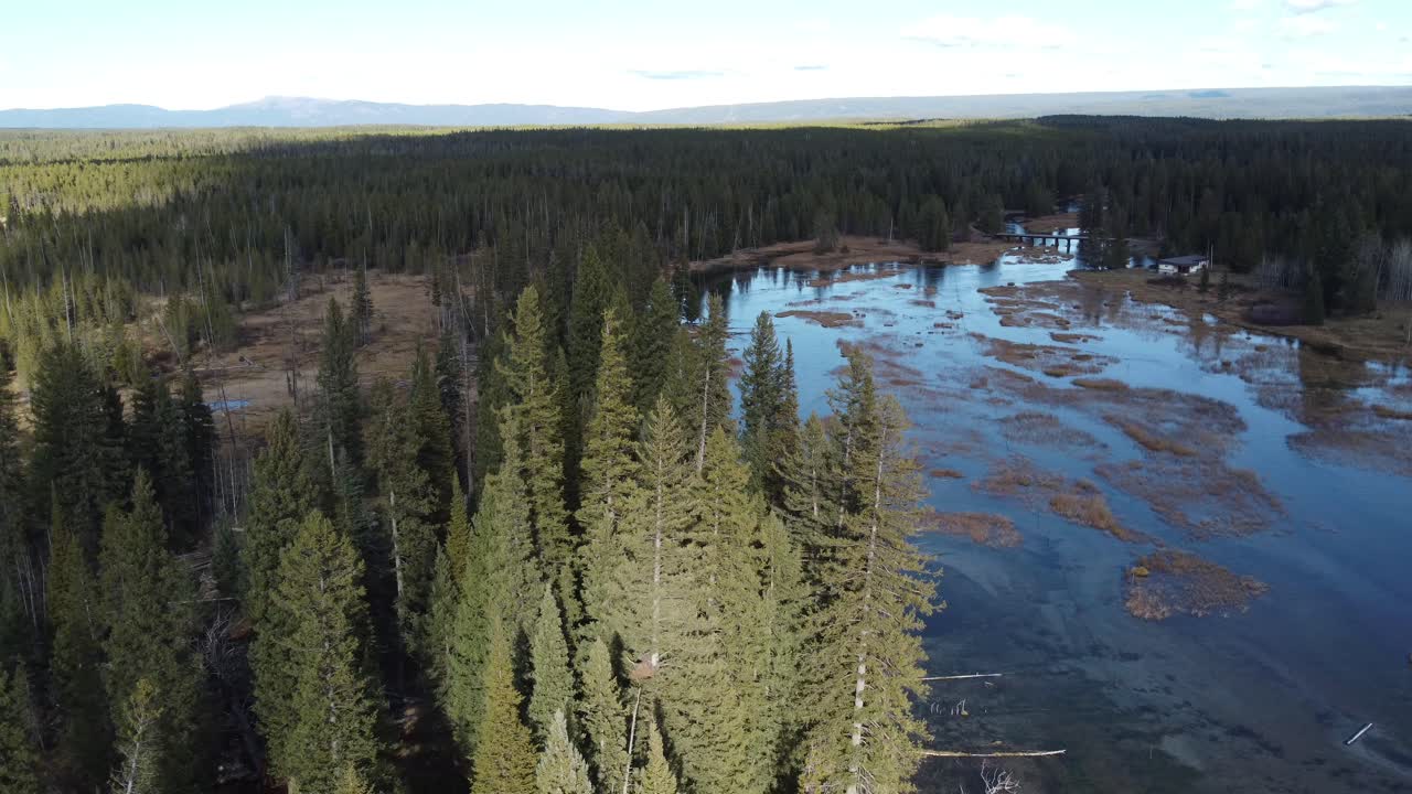 Island Park, Idaho, aerial clip highlighting river channels, wetland terrain, and a quiet cabin in the forest. Great for outdoor storytelling