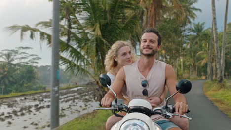 pareja feliz montando un scooter en una isla tropical mujer feliz celebrando con los brazos levantados disfrutando de una aventura romántica con su novio en un paseo en motocicleta en la niebla de la mañana