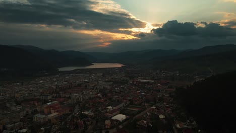 backward-aerial-of-Piatra-Neamt-Lake-And-City-View-On-Sunset-Golden-Hour