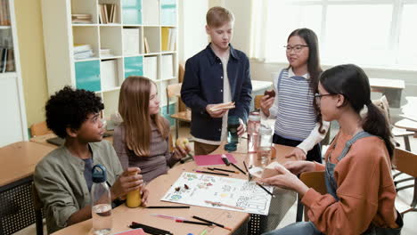 a group of diverse students eating snacks and socializing in a classroom