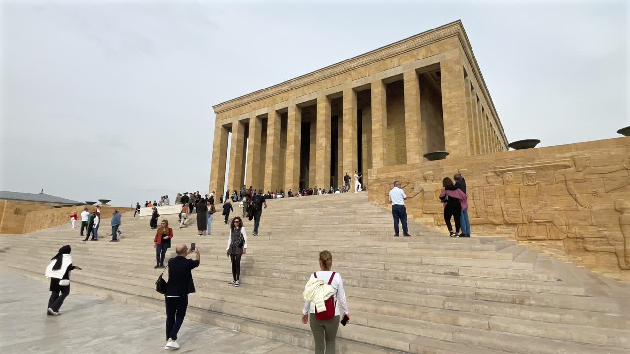 Turkey,Ankara, Ataturk's Mauseloum on a cloudy day. People climbing the stairs to reach the mausoleum, some people take photos in front of the monument.