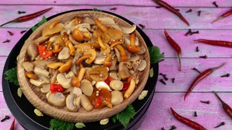 pickled honey mushrooms sprinkled with allspice peas rotate slowly on turntable red capsicum beside.