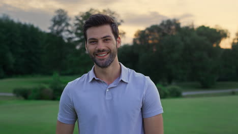 happy golf man smiling look camera on sunset field. sportsman enjoy active life.