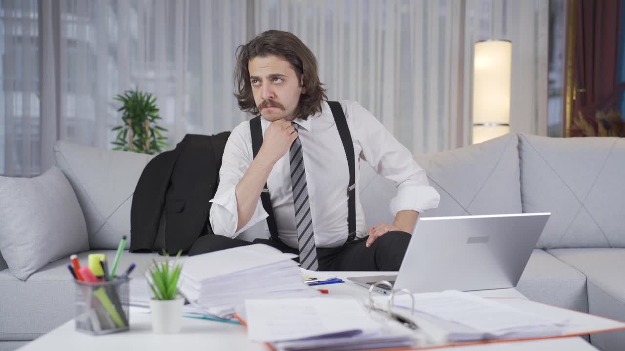 가정 사무실에서 일하는 사려 깊은 사업가입니다.