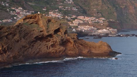 aerial scenic of porto moniz coastal village, reveal over sharp rock formation