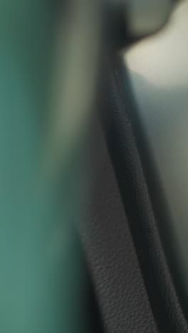 female hand with red manicure turns key starting engine of personal car and turns steering wheel. driver controls automobile closeup soft focus