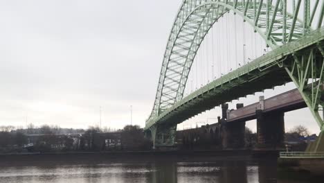 runcorn silver jubilee suspension bridge reflections rippling in river mersey below pan left tilt down