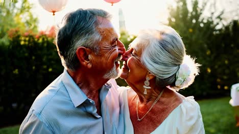 happy elderly couple kissing at an outdoor celebration