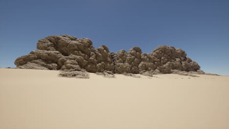 sand dunes and rugged rock formations in a vast desert landscape