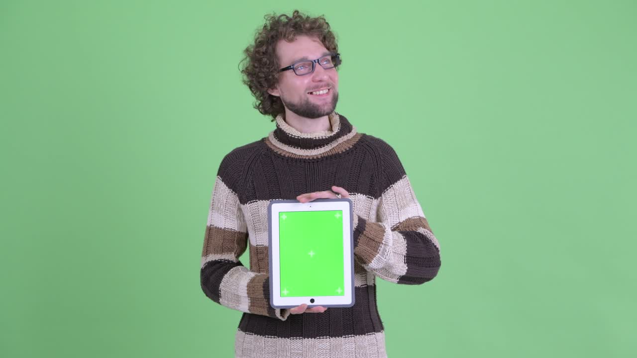 un joven guapo con barba y cabello rizado.