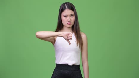 young beautiful asian businesswoman giving thumbs down