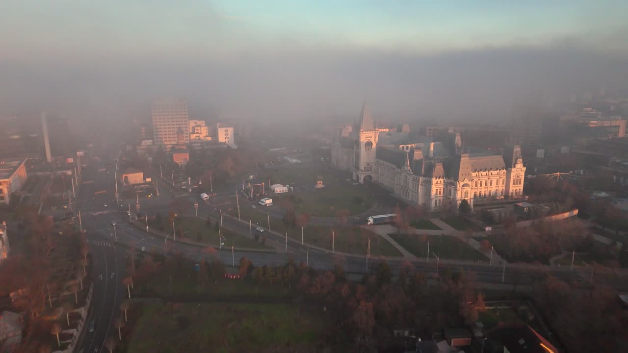 video de avión no tripulado del palacio de la cultura en iasi con niebla, tráfico y edificios circundantes