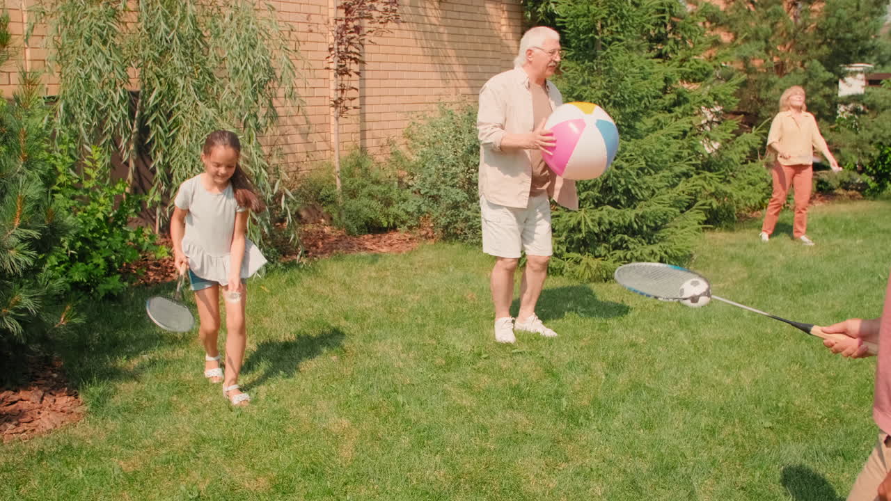 Family Playing Sports Outdoors In Backyard