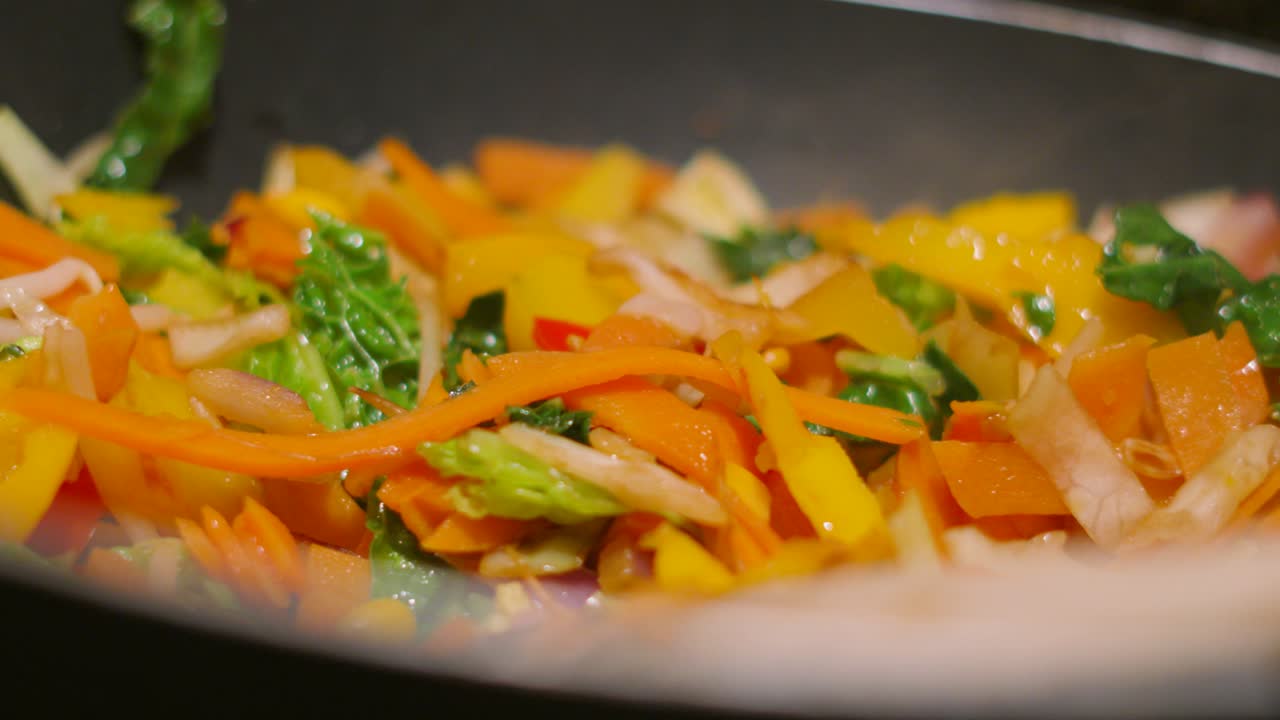 Side View of Steaming Very Hot Stir Fry Vegetables in Wok Pan with Shallow Depth of Field 4K