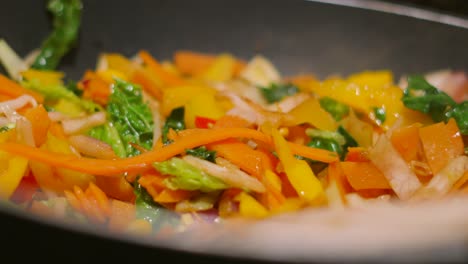 side view of steaming very hot stir fry vegetables in wok pan with shallow depth of field 4k