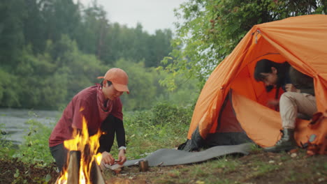 female tourists keeping fire at campsite