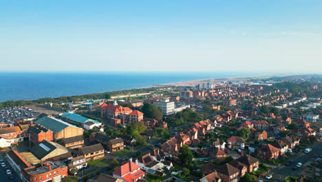 Discover-the-coastal-beauty-of-Skegness,-Lincolnshire,-through-stunning-aerial-footage,-highlighting-the-bustling-beach,-amusements,-famous-pier,-and-a-summer-evening