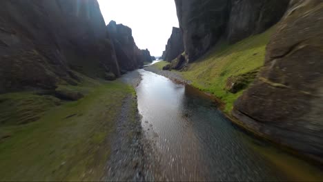 vuelo de proximidad de drones fpv de baja altitud sobre un río que atraviesa un cañón en islandia