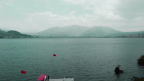vista aérea del muelle vacío de la marina en la costa del lago san pablo en otavalo con pedestal arriba, muñeca hacia adelante
