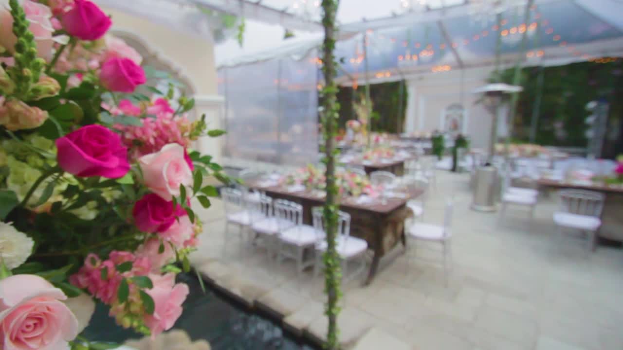 Flowers Arrangement with pink and purple roses in the table for a wedding