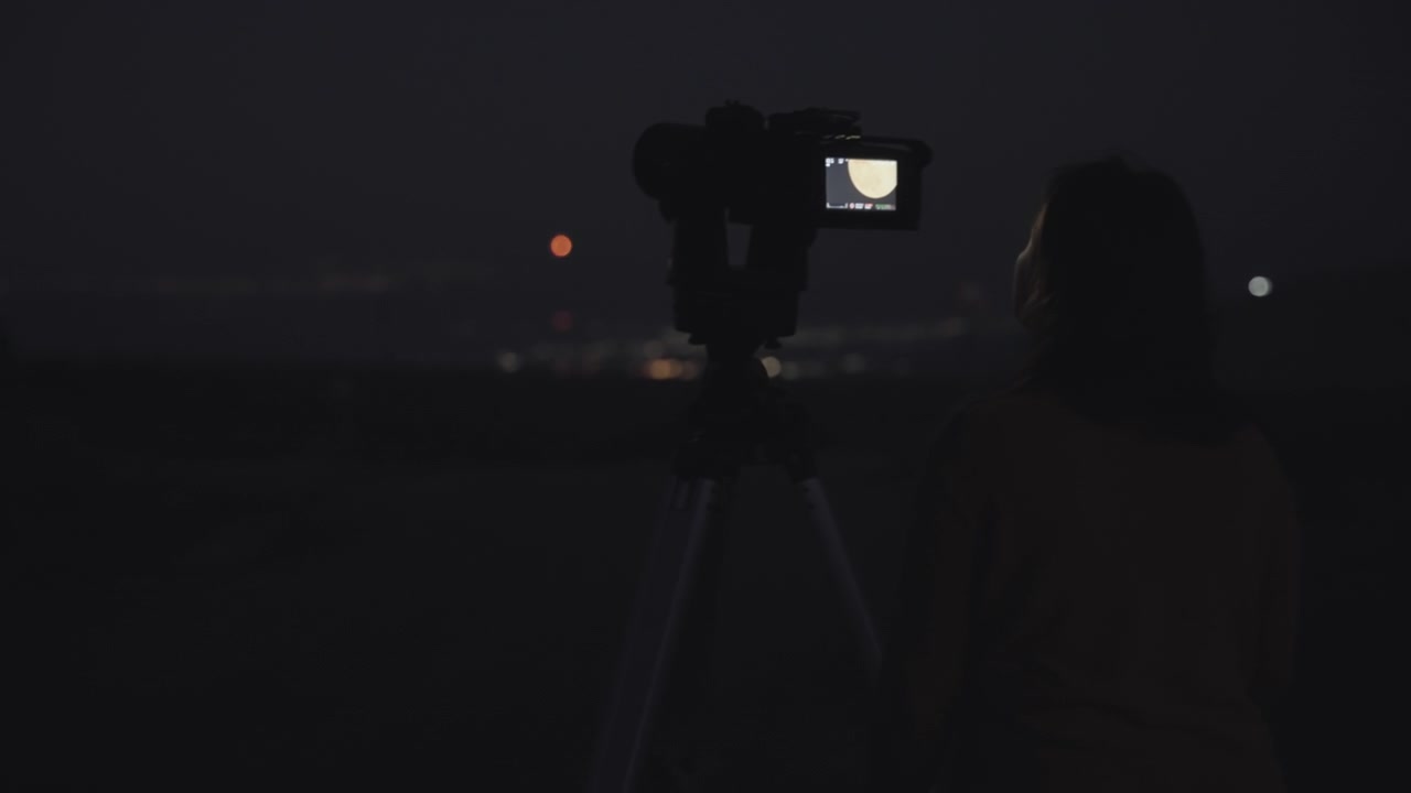 Donna che fotografa la luna piena