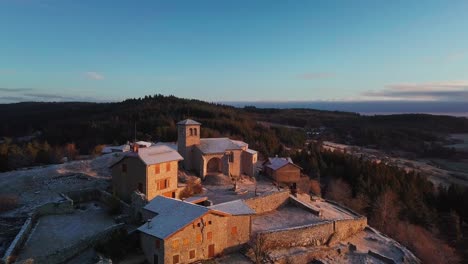 aerial orbital shot around the town of Montarcher on a forsty sunrise in Loire Departement, Auvergne RHone Alpes Region, France