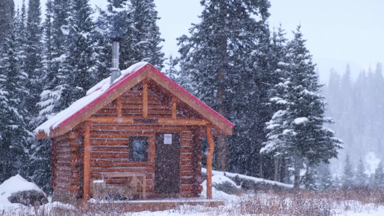 cabaña acogedora en las montañas rocosas canadienses durante una tormenta de nieve