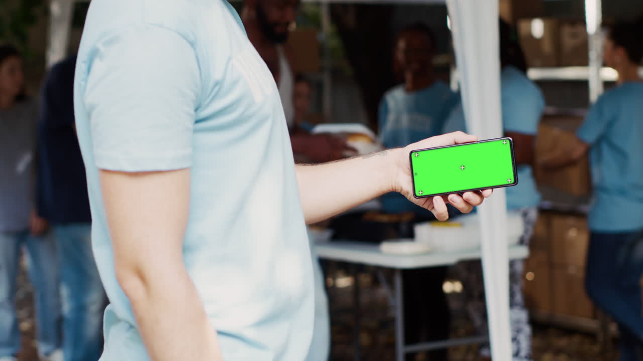 hombre agarrando un teléfono celular con pantalla verde