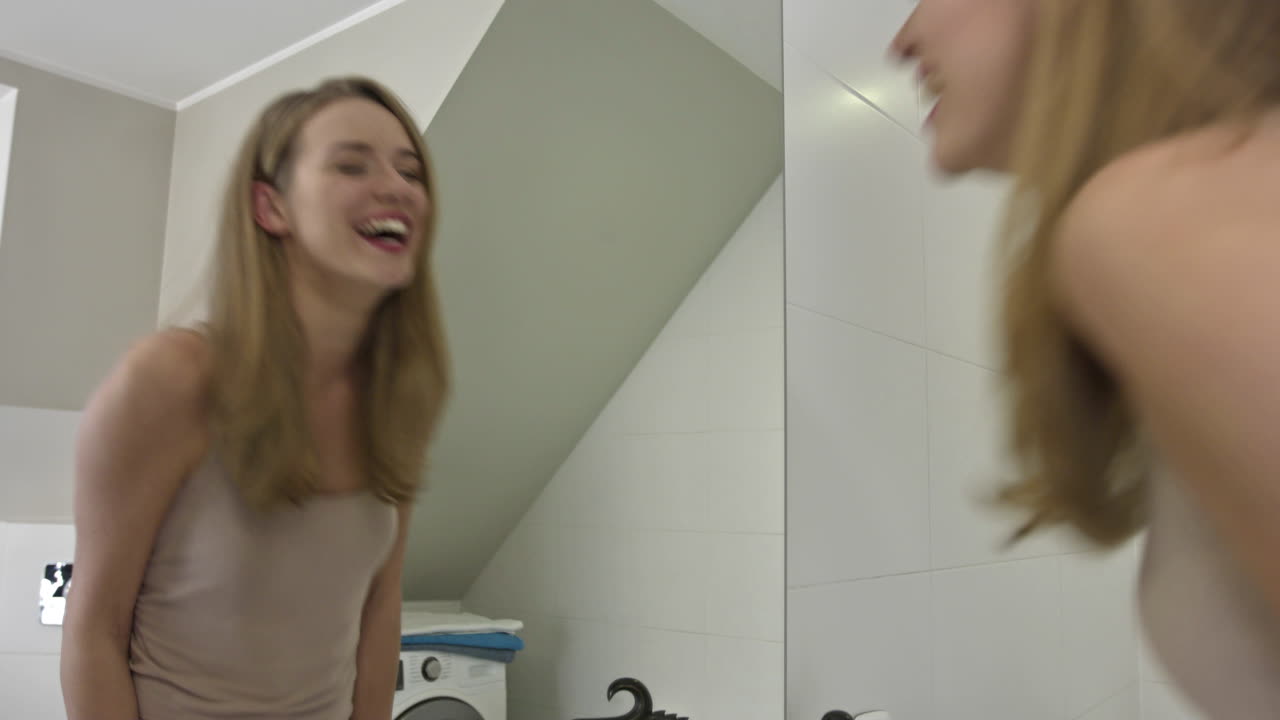 happy woman kissing mirror in her bathroom