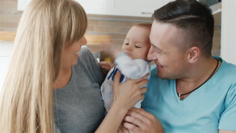 una feliz madre de familia padre e hijo de dos meses sostienen al bebé en sus brazos