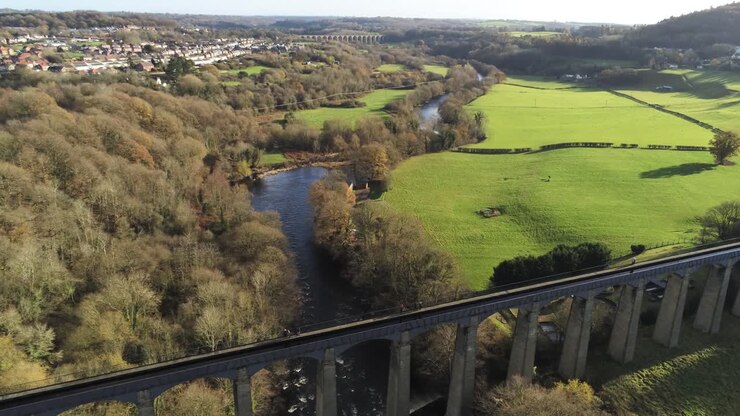 Old Welsh Pontcysyllte Aqueduct waterway aerial view rural Autumn woodlands valley rising dolly left