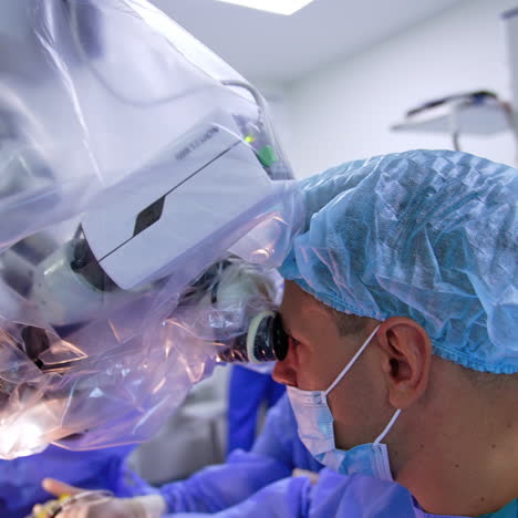 advanced microscope covered in plastic. male surgeon looks into binocular performing tools.