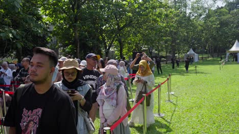 indonesian crowd queueing to enter during an outdoor event in kebun raya bogor, indonesia. tracking shot
