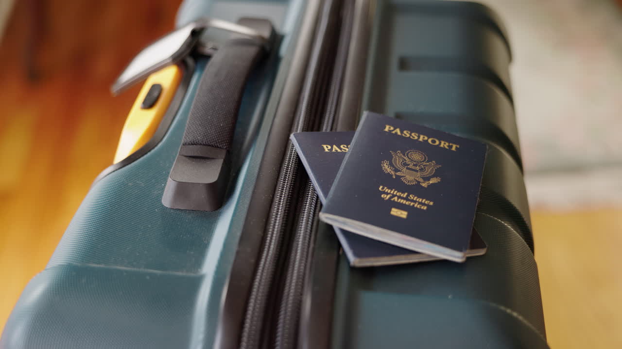 Mano che posa passaporti statunitensi su una valigia
