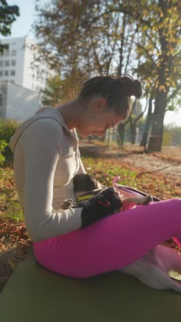 woman holding a pug in a park