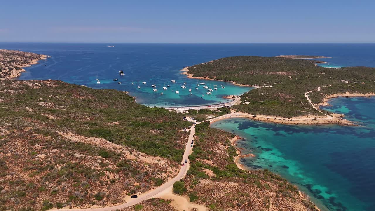 Yachts anchor in a serene lagoon under a sunny sky, aerial view
