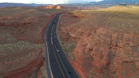 vehicles driving at asphalt road between eroded mountain in st