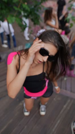 woman at a party wearing sunglasses and a pink skirt