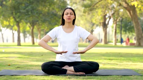 indian woman doing breathe in breathe out exercise in a park in morning