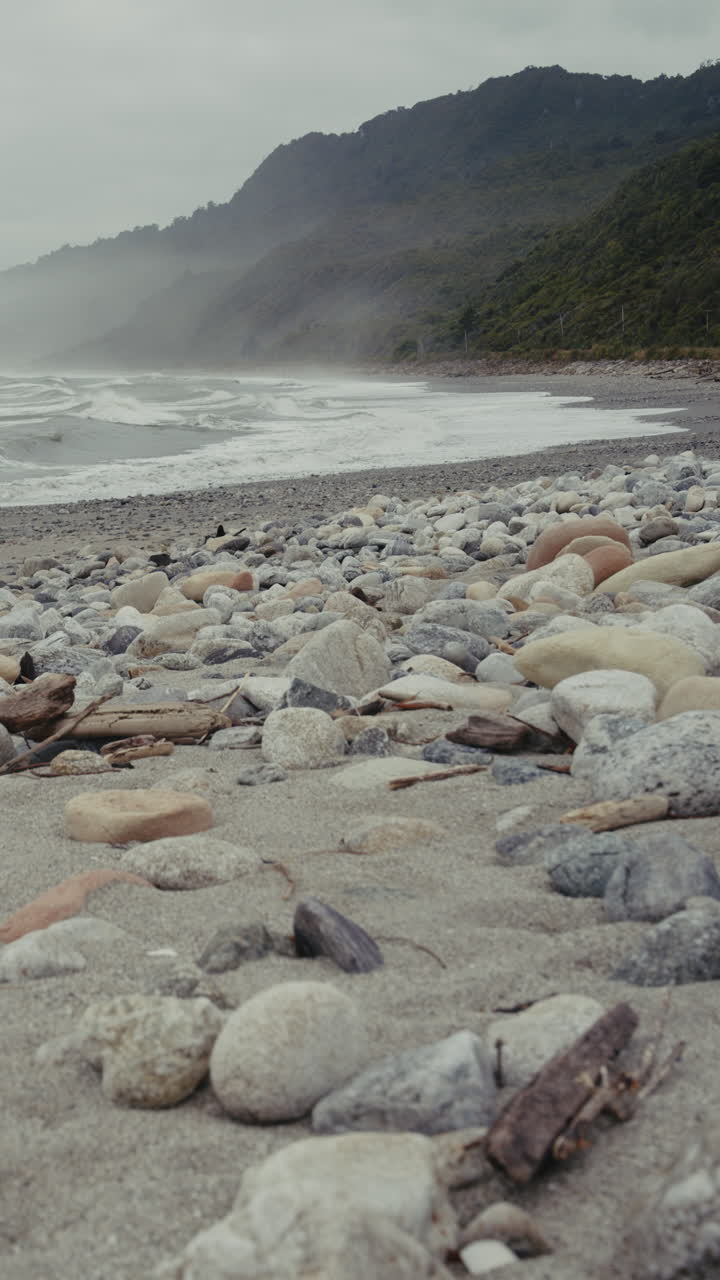 Rocky Beach Scene with Foggy Mountains