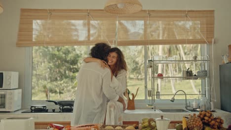 couple kissing in a tropical kitchen