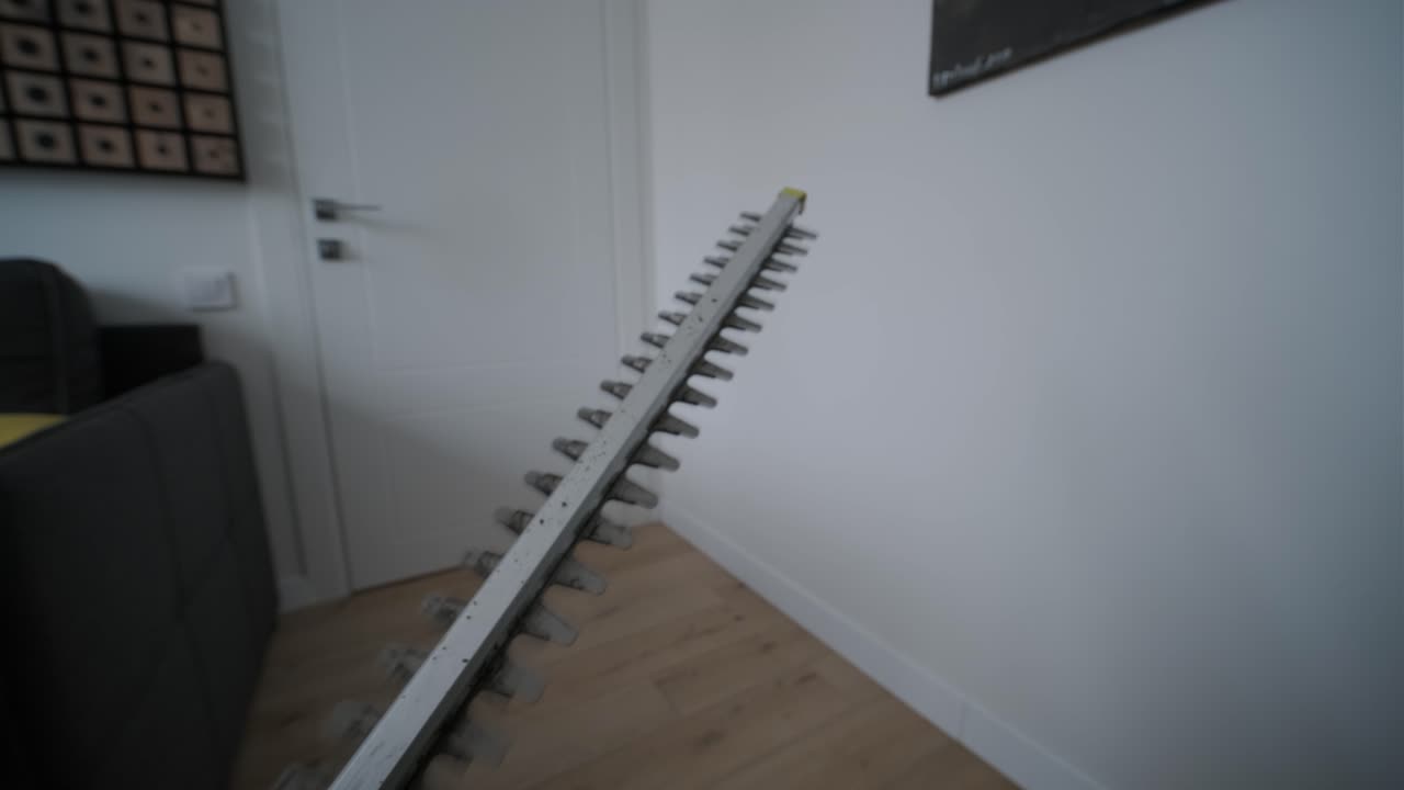 Nærbillede af et hækkeklipperblad, der er i brug indendørs.