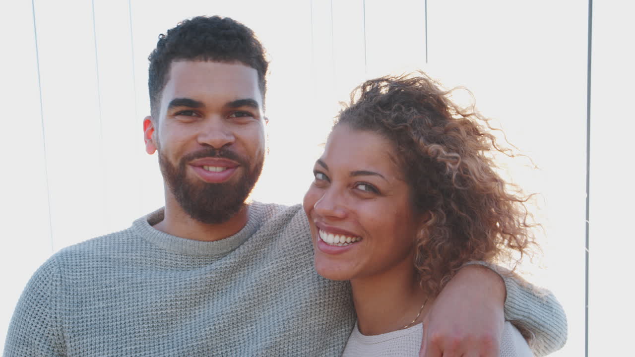 Backlit Portrait Of Loving Couple Standing On Bridge In City Together