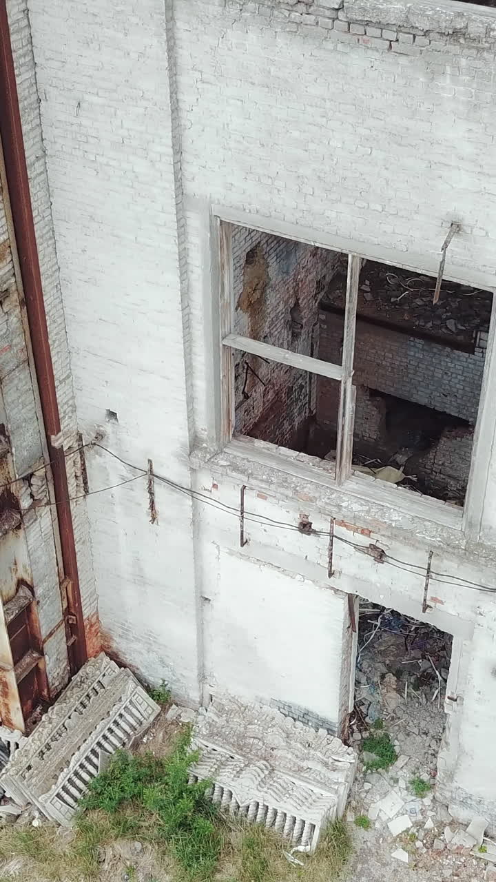 Aerial view of a destroyed factory during the war. Abandoned industrial building.. Vertical video