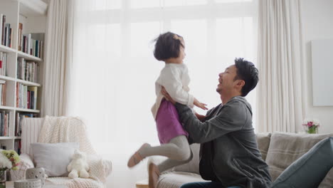 cute-little-asian-girl-jumping-into-fathers-arms-happy-dad-gently-catching-his-daughter-enjoying-playful-game-with-child-at-home-4k